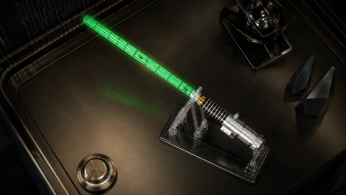 Spada laser verde in mattoncini su base nera, vista dall'alto su un piano scuro