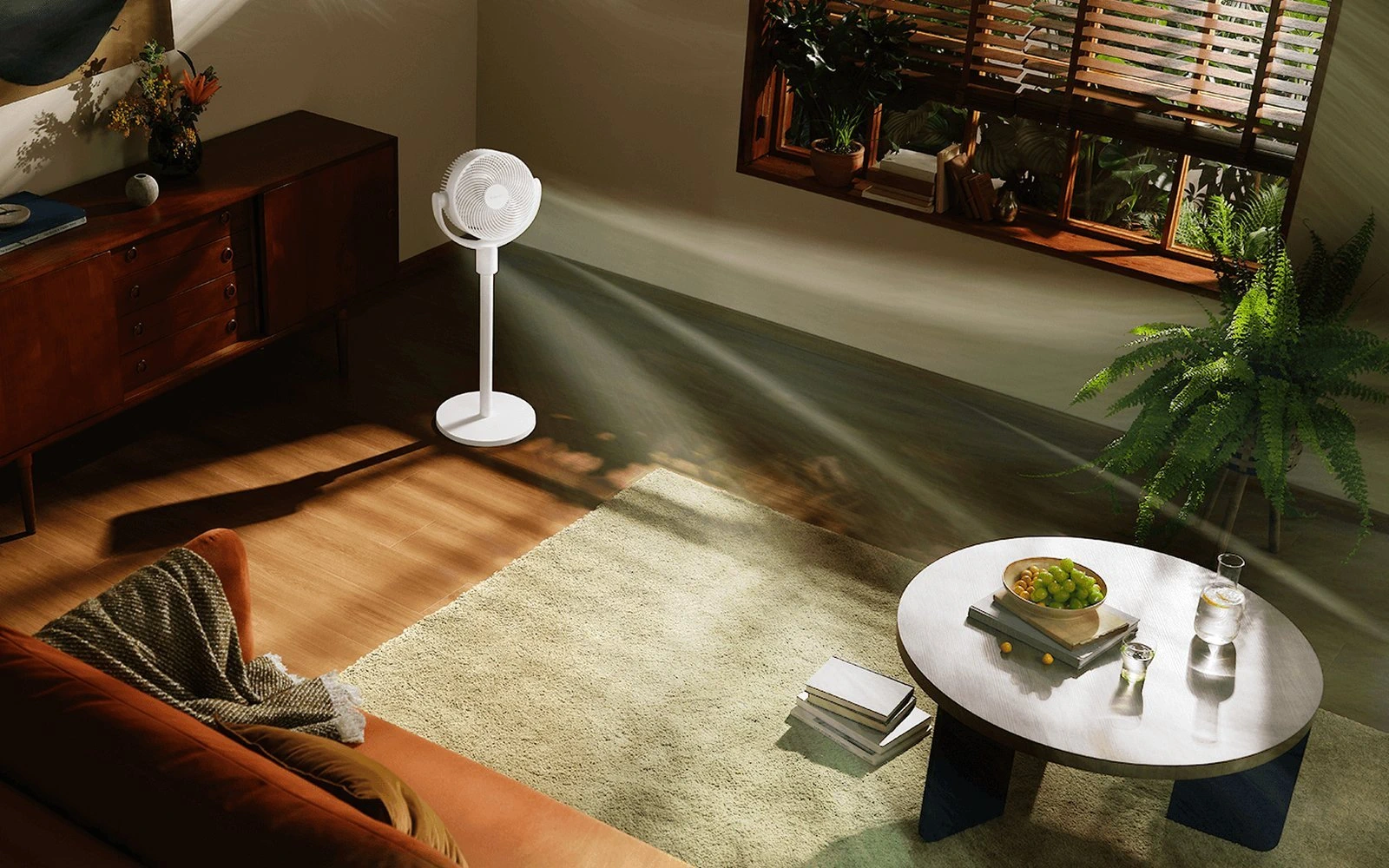 Weißer Standventilator in einem sonnendurchfluteten Wohnzimmer mit sichtbarem Luftstrom