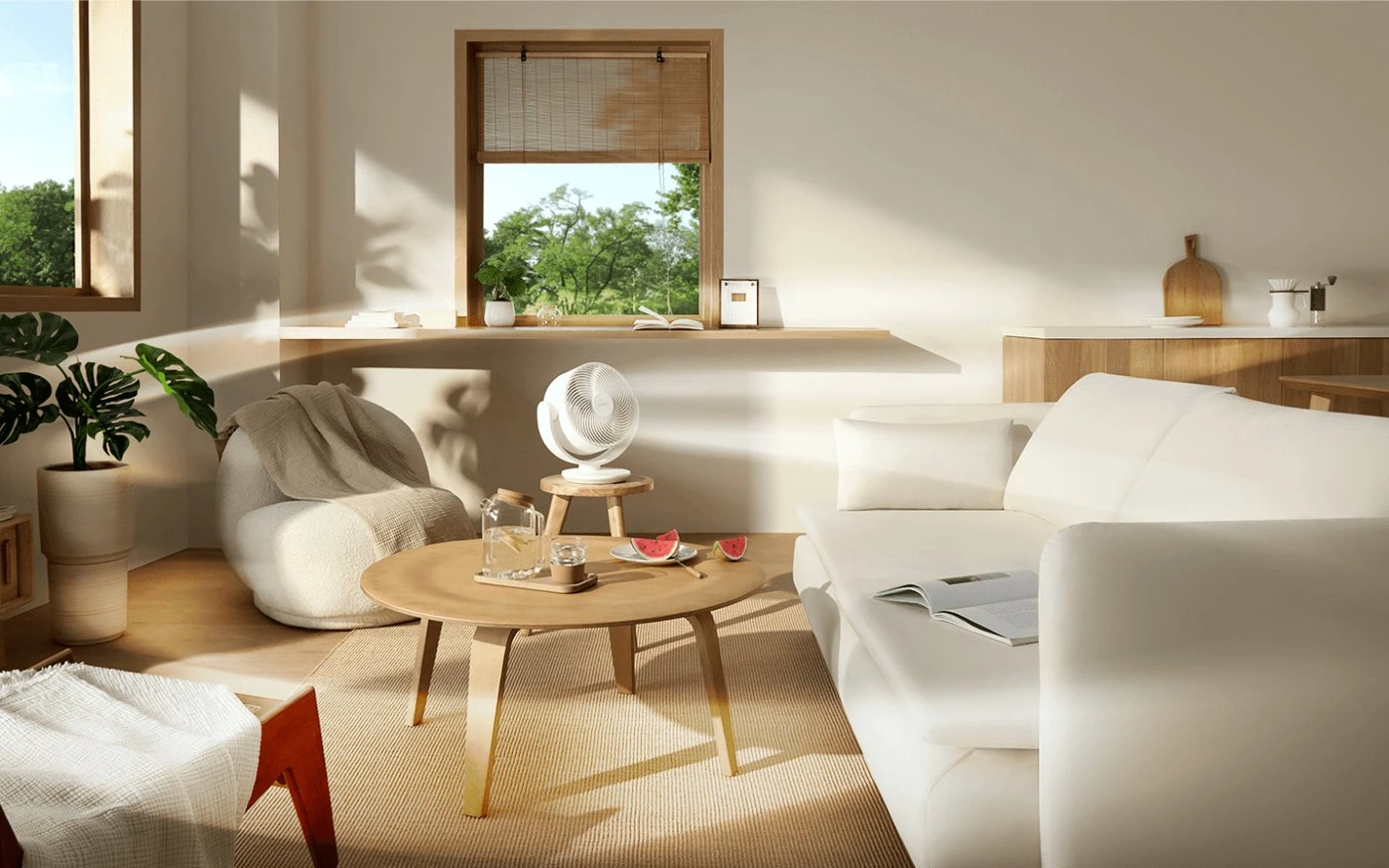 Salón moderno con un ventilador Xiaomi blanco sobre un taburete, rodeado de muebles claros, plantas y luz solar entrando por la ventana