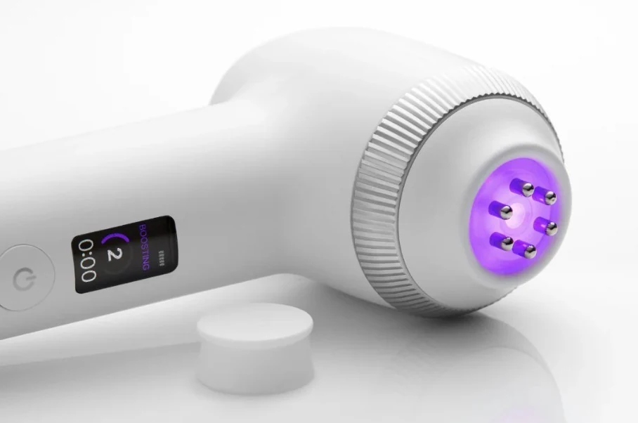 Dispositivo branco Age-R Ultra com visor e cabeça roxa com saliências, ao lado de uma base branca.