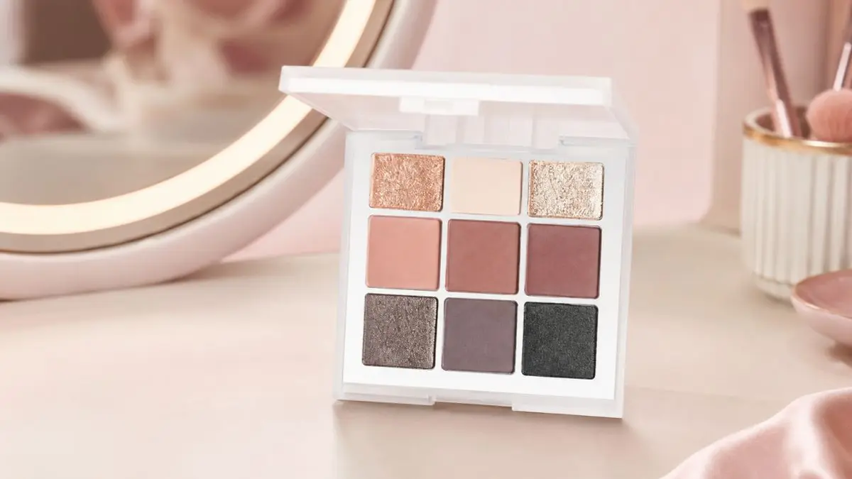 Paleta LOVRO Moderate de nove sombras ao lado de um espelho e pincéis de maquilhagem
