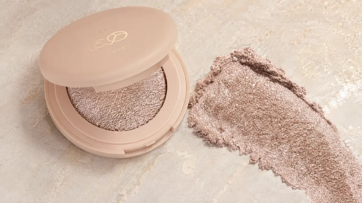 Открытый LOVRO Wet Glow рядом с образцом переливающейся формулы на светлом фоне