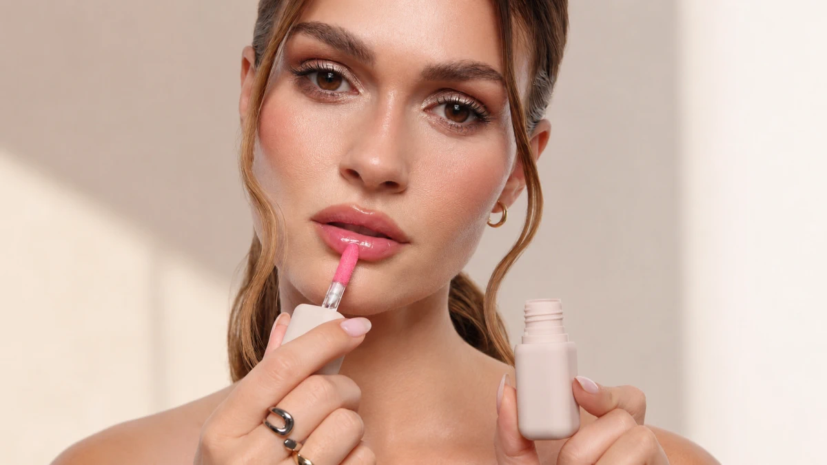 Mulher aplicando o óleo tintado POPPY HEAD Sheerious Lip Tint nos lábios
