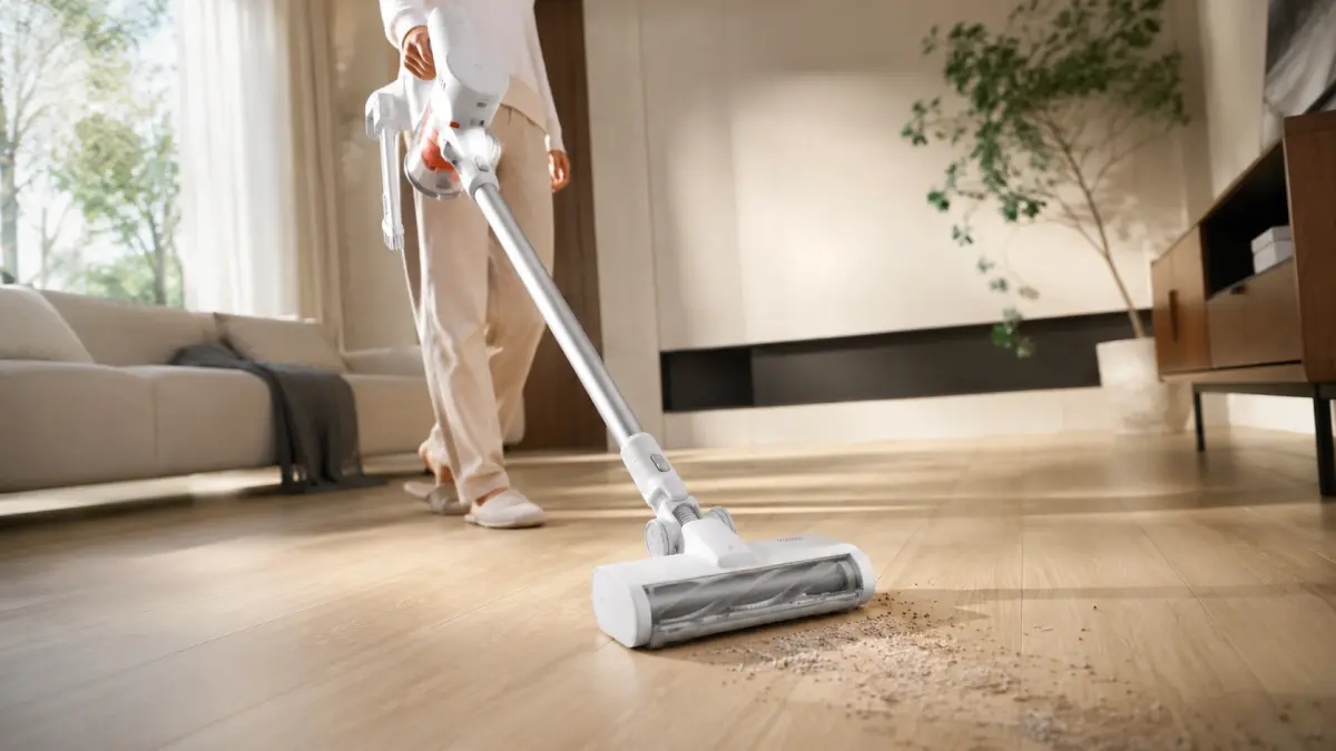 Odkurzacz pionowy Xiaomi Mijia Vacuum Cleaner 4 C EU podczas usuwania zabrudzeń z drewnianej podłogi w jasnym salonie