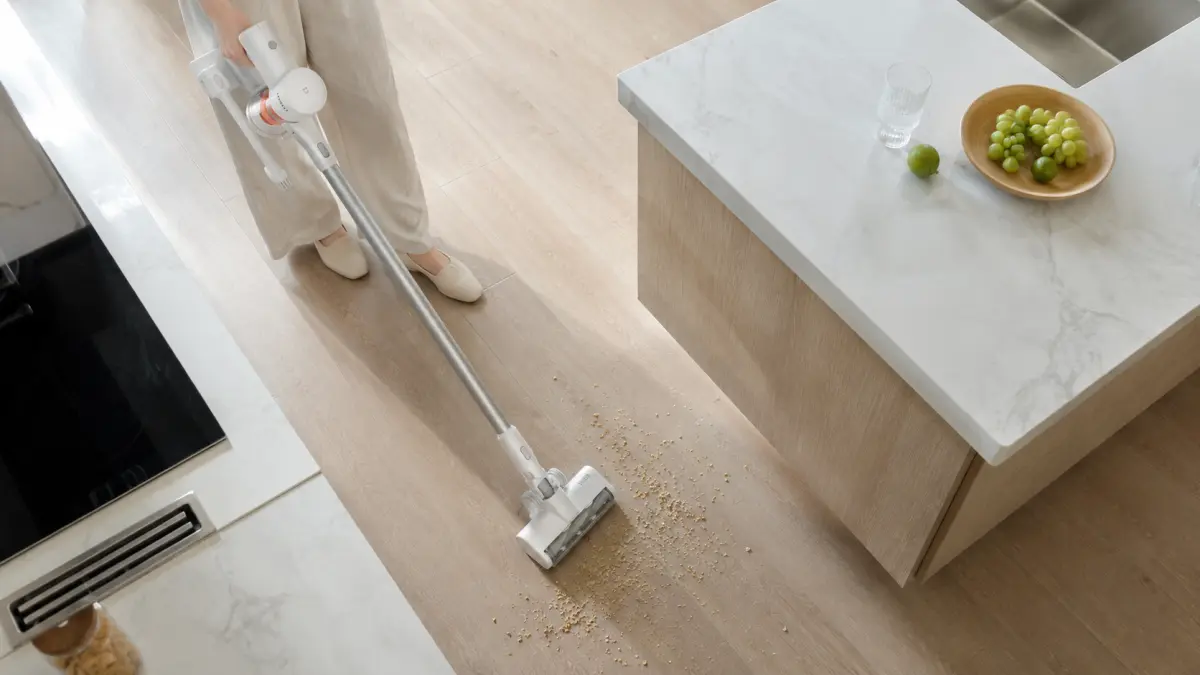 Odkurzacz pionowy Xiaomi zbierający rozsypane ziarna z podłogi przy kuchennej wyspie